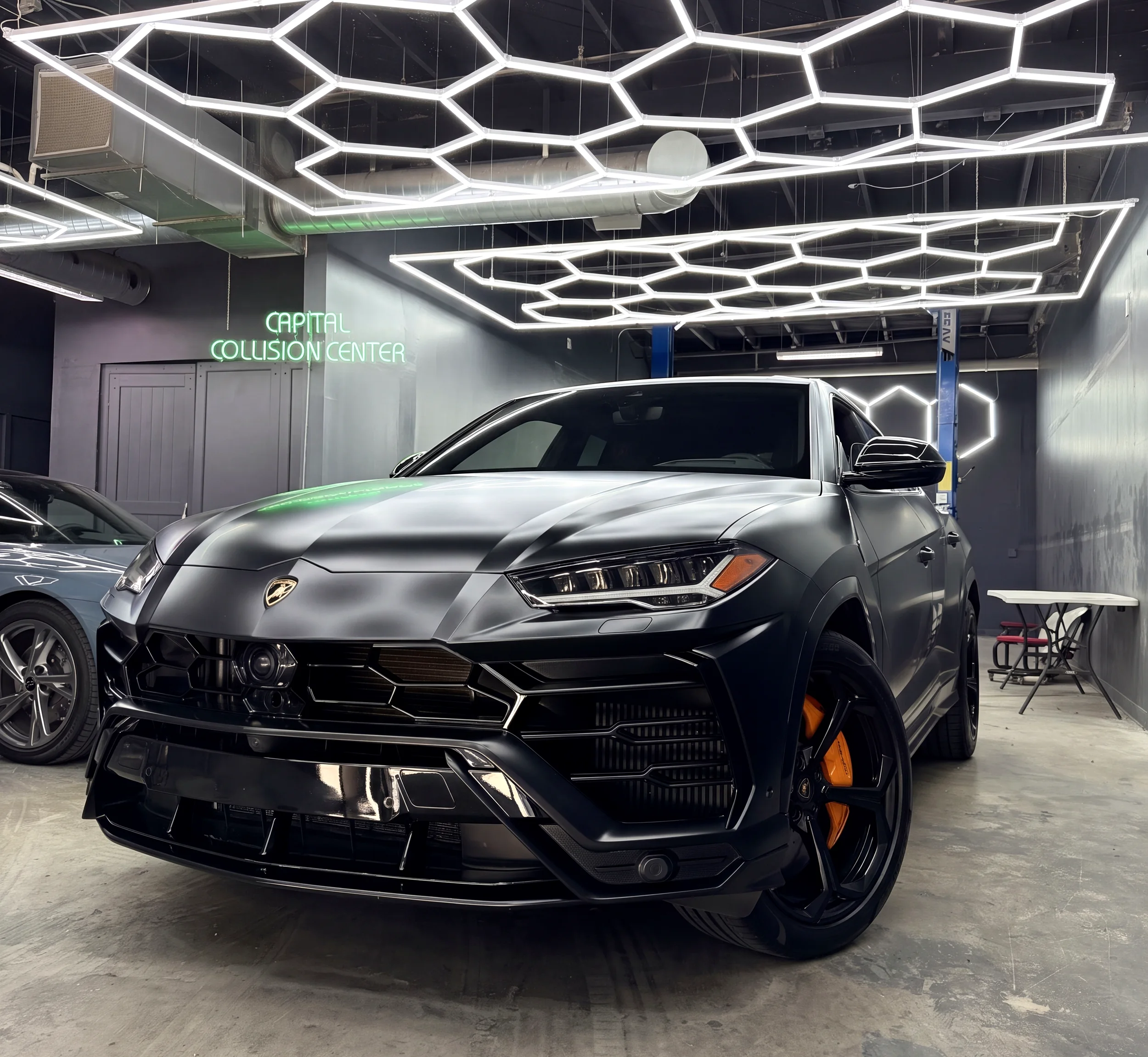 Matte black Lamborghini Urus inside the Capital Collision Center shop
